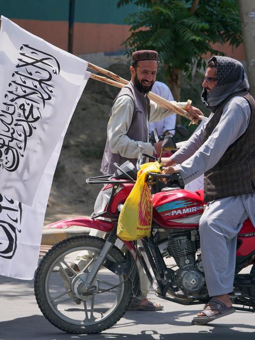 Ein Mann bietet Taliban-Flaggen zum Verkauf in Kabul an. Ein Mann bietet Taliban-Flaggen zum Verkauf in Kabul an.