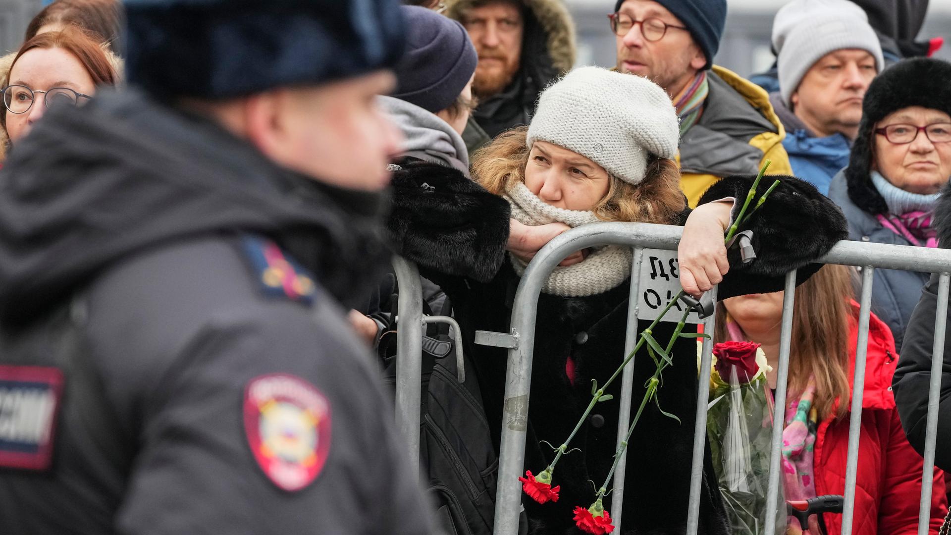 Moskau: Ein Polizist bewacht Zaungäste in der Nähe der Kirche zu Ehren der Gottesmutterikone "Lindere meine Trauer" im südöstlichen Bezirk Marjino, in der Kremlgegner Alexej Nawalny beigesetzt werden soll. Moskau: Ein Polizist bewacht Zaungäste in der Nähe der Kirche zu Ehren der Gottesmutterikone "Lindere meine Trauer" im südöstlichen Bezirk Marjino, in der Kremlgegner Alexej Nawalny beigesetzt werden soll.