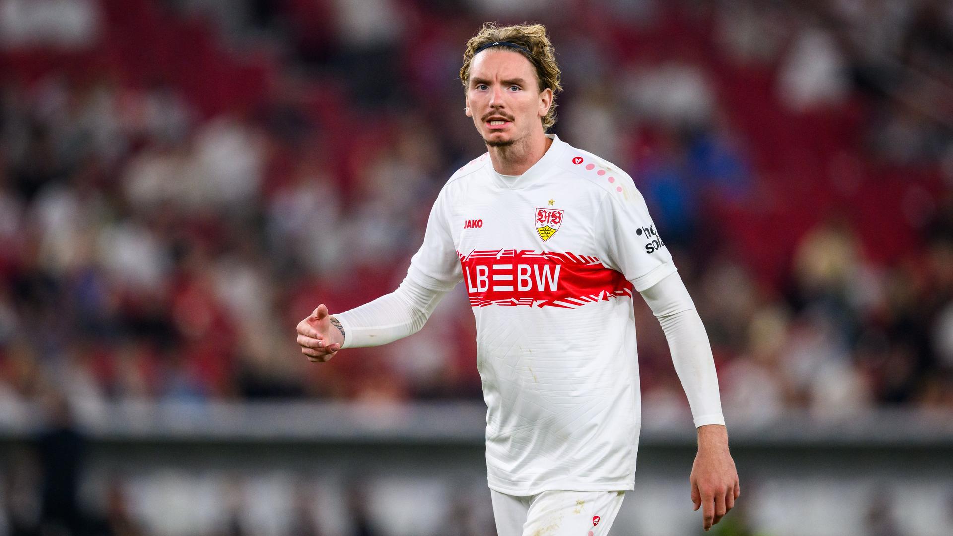 Nick Woltemade steht im Stadion auf dem Platz. Er trägt ein Trikot des VfB Stuttgart.