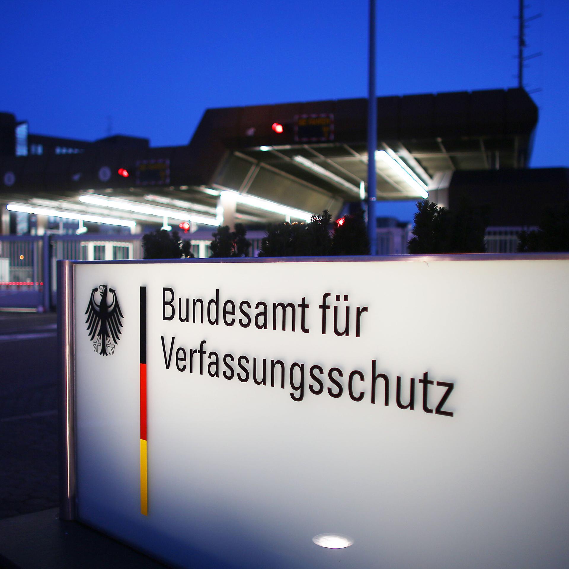 Nachtaufnahme eines beleuchteten Schildes mit der Aufschrift "Bundesamt für Verfassungsschutz" 