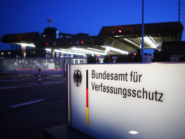 Nachtaufnahme eines beleuchteten Schildes mit der Aufschrift "Bundesamt für Verfassungsschutz" 