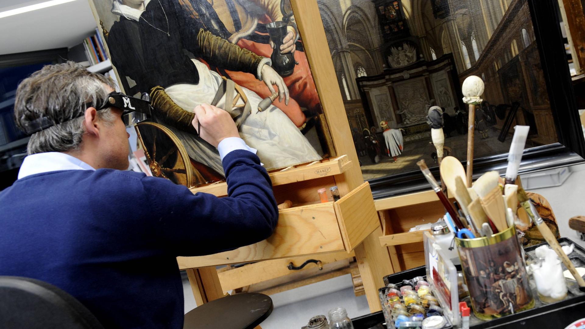 Restaurator bei der Arbeit an einem Gemälde im Rijksmuseum in Amsterdam, Niederlande Restaurator bei der Arbeit an einem Gemälde im Rijksmuseum in Amsterdam, Niederlande