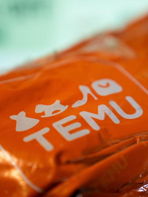 Das Bild zeigt ein orangenes Paket mit der Aufschrift "Temu". (Photo by Nikos Pekiaridis/NurPhoto)