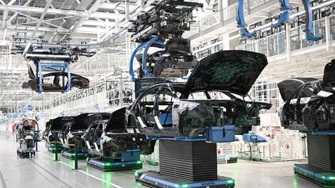 In einer Fabrik in Sindelfingen werden Karosserien für Mercedes-Benz-Fahrzeuge automatisiert transportiert.