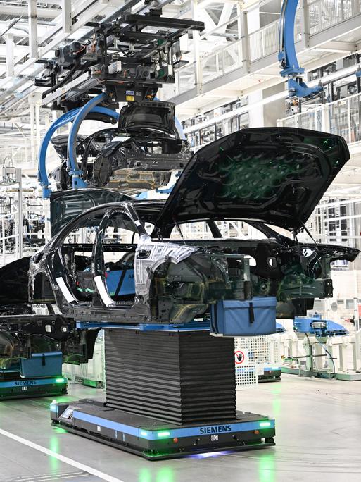 In einer Fabrik in Sindelfingen werden Karosserien für Mercedes-Benz-Fahrzeuge automatisiert transportiert.
