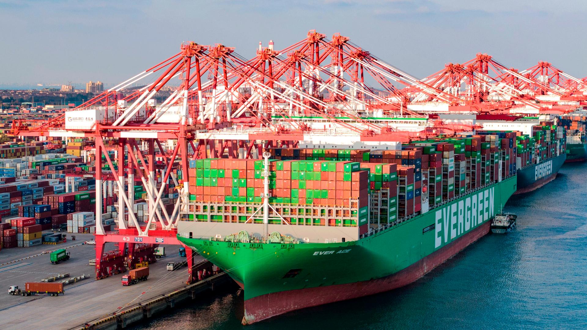 Ein Superklasse-Containerschiff entlädt Container am Qianwan-Containerterminal des Hafens von Qingdao in der Provinz Shandong.