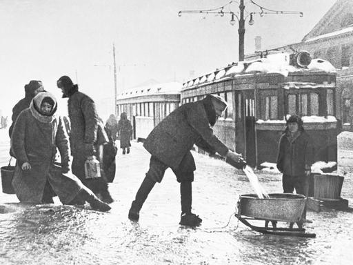 Während der Blockade von Leningrad im Winter 1942 entnehmen Menschen Wasser an einer öffentlichen Wasserleitung.  