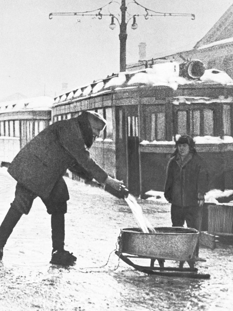 Während der Blockade von Leningrad im Winter 1942 entnehmen Menschen Wasser an einer öffentlichen Wasserleitung.  