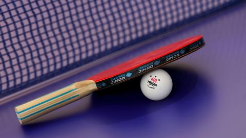 Ein Tischtennisschläger liegt auf einem Ball.