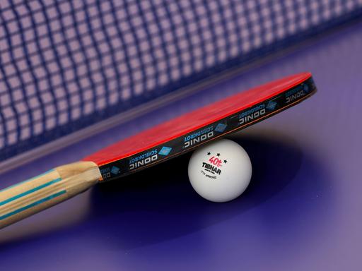 Ein Tischtennisschläger liegt auf einem Ball.