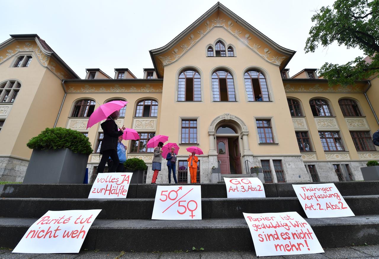 Demonstrantinnen für eine Paritätsregelung stehen vor der Urteilsverkündung mit Plakaten wie "Parité tut nicht weh" vor dem Thüringer Verfassungsgerichtshof.