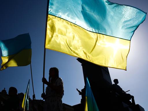 Nationalflaggen der Ukraine in gelb und blau werden bei einer Demonstration geschwenkt, 2023.