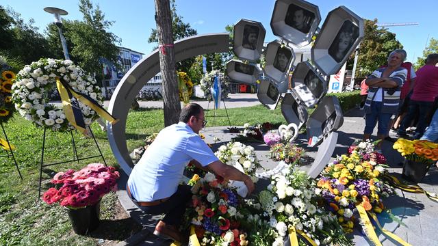 Bei einer Gedenkveranstaltung zum neunten Jahrestag des rechtsextremen Anschlags am Olympia-Einkaufszentrum (OEZ) 2016 in München legen Angehörige und Trauernde Blumen und Kränze am Denkmal vor dem OEZ nieder.