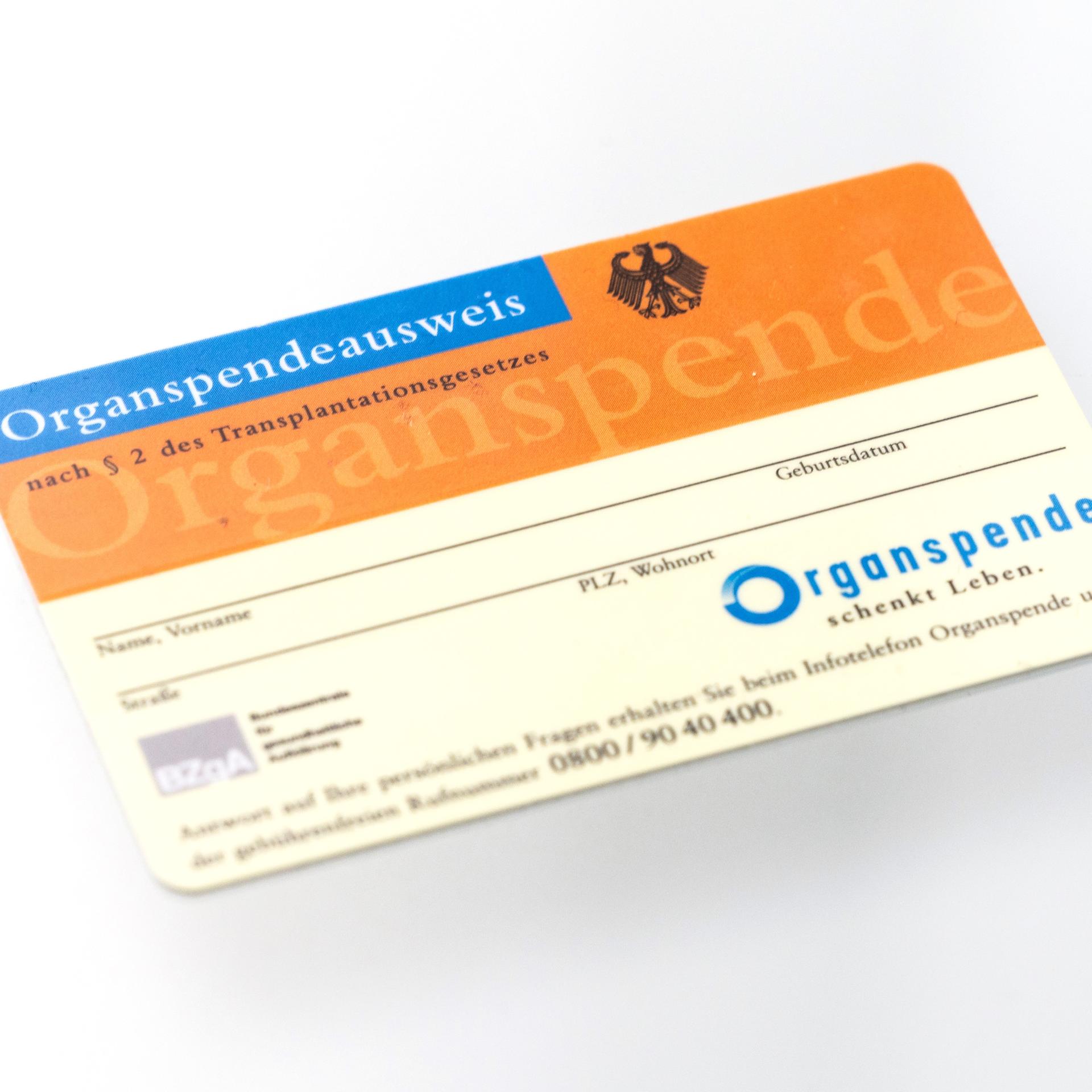 Ein Organspendeausweis spiegelt sich in einem Glastisch. Die Deutsche Stiftung Organtransplantation (DSO).