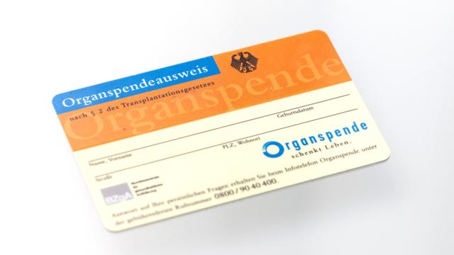 Ein Organspendeausweis spiegelt sich in einem Glastisch. Die Deutsche Stiftung Organtransplantation (DSO).