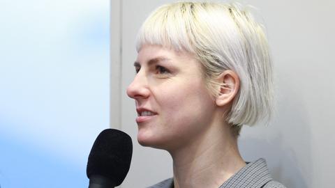 Die Schriftstellerin Helene Bukowski im Profil mit einem Mikrofon in der Hand.