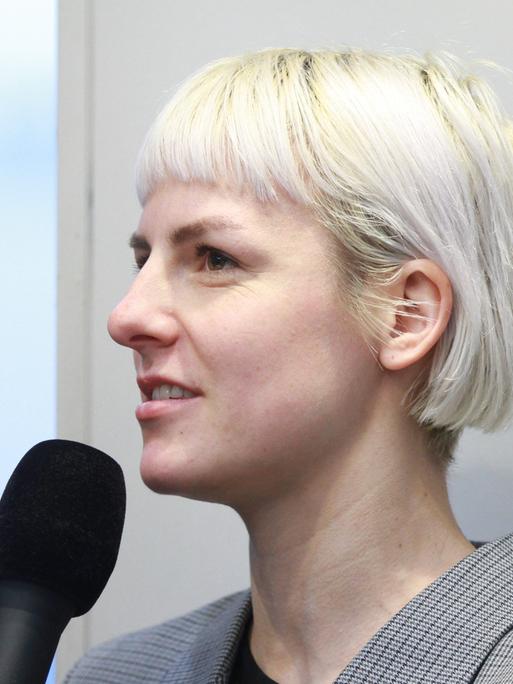 Die Schriftstellerin Helene Bukowski im Profil mit einem Mikrofon in der Hand.