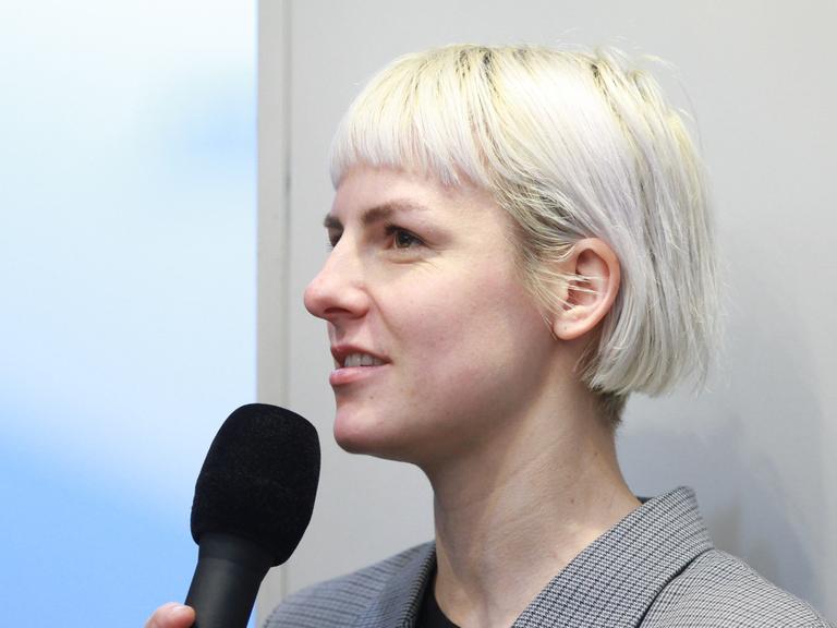 Die Schriftstellerin Helene Bukowski im Profil mit einem Mikrofon in der Hand.