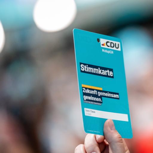 Eine Delegierte hält beim CDU-Bundesparteitag die Stimmkarte hoch. Beim Parteitag der Union wird die Führungsspitze neu gewählt und ein neues Grundsatzprogramm beschlossen.