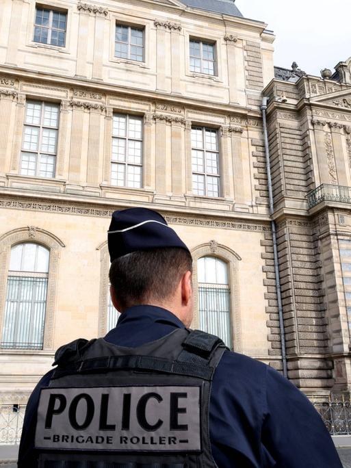 Vor dem Louvre steht ein Polizist. Vor dem Louvre steht ein Polizist.