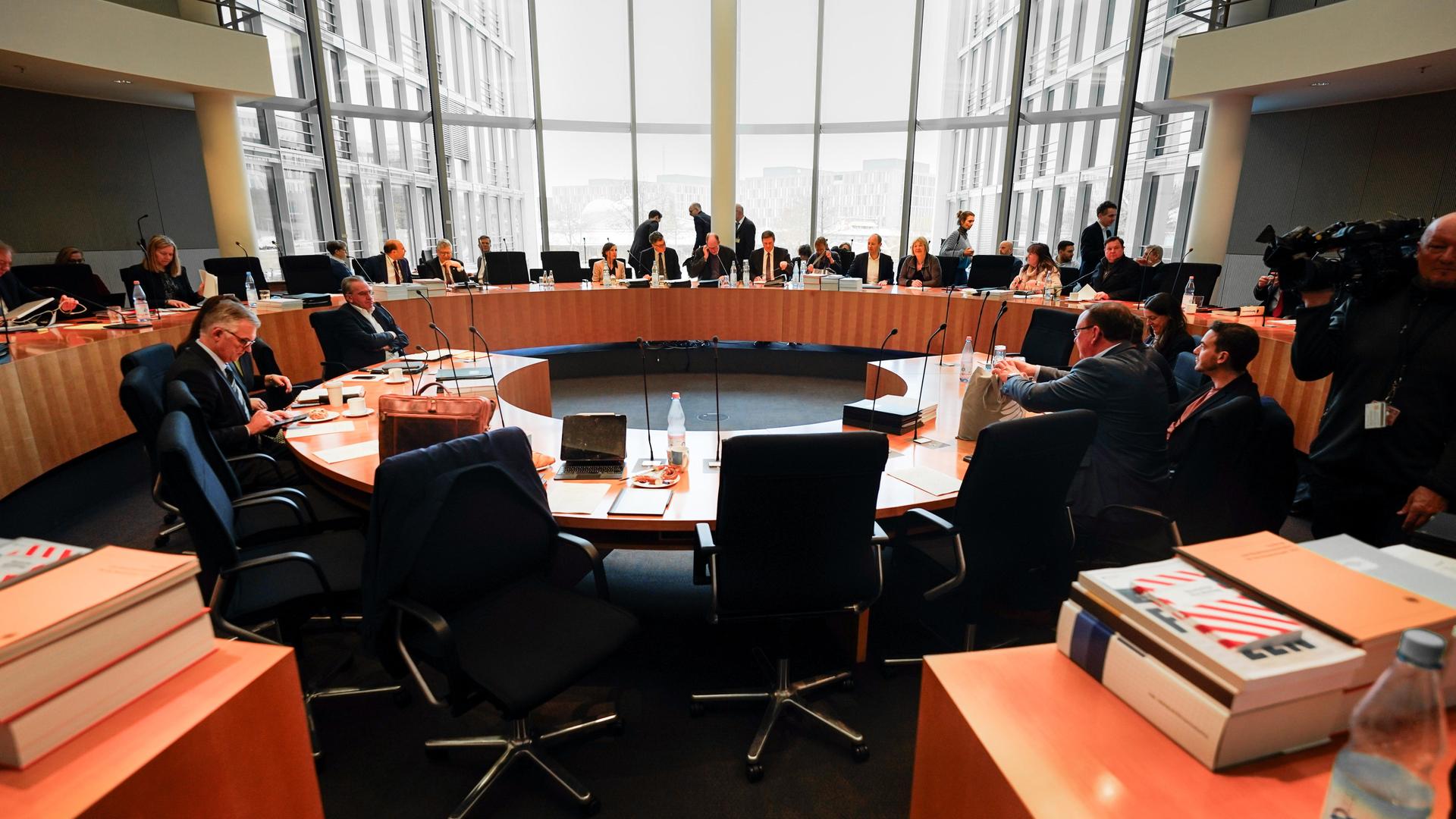 Mitglieder des Haushaltsausschuss sitzen an runden Tischen.