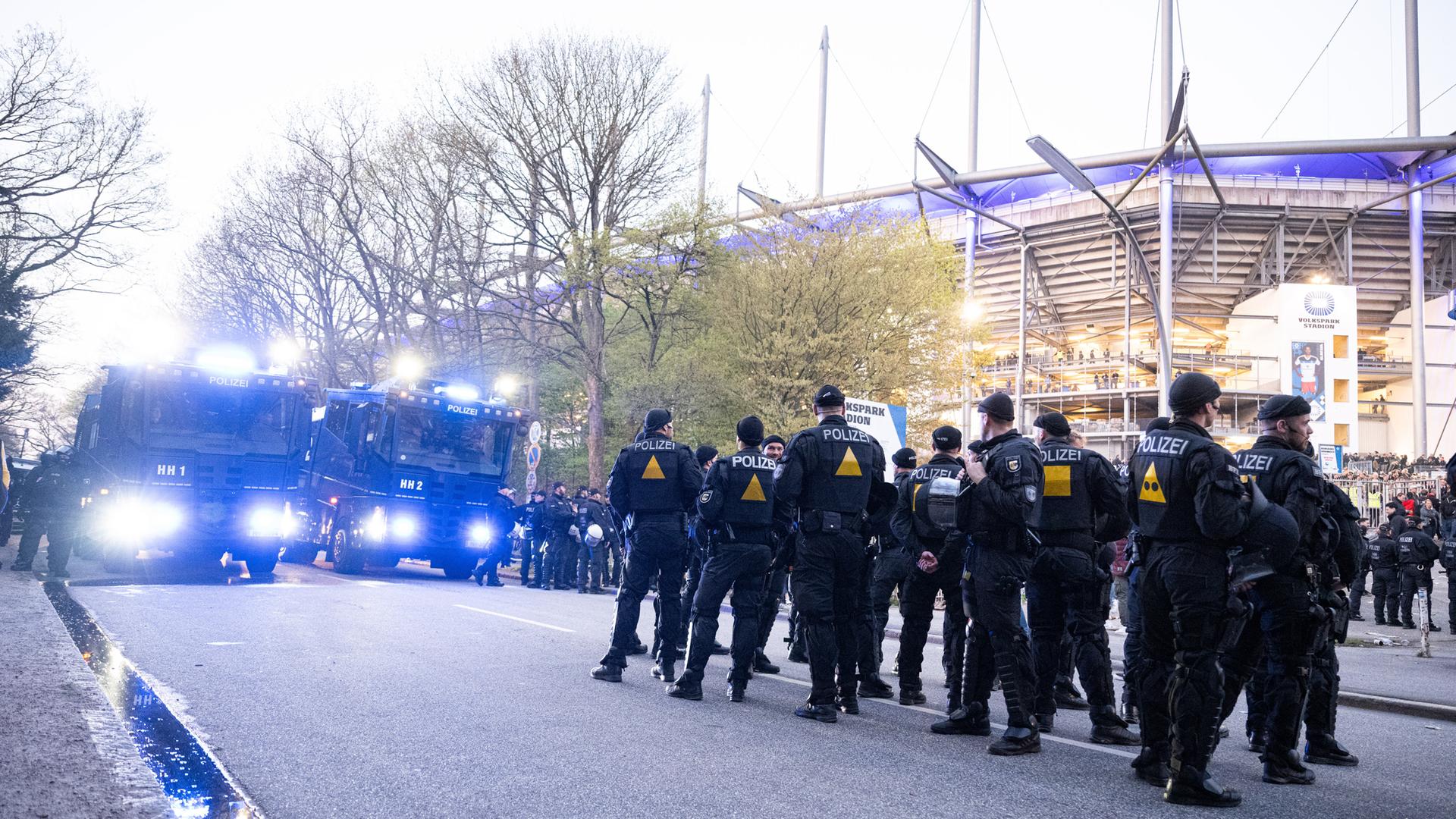 Polizeibeamte und Wasserwerfer stehen nach dem Spiel vor dem Hamburger Volksparkstadion.