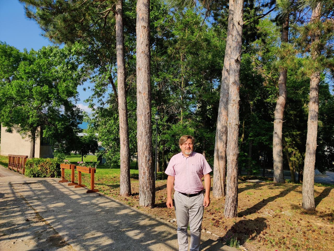 Ein Mann steht zwischen Bäumen Nikolaj Nenkov