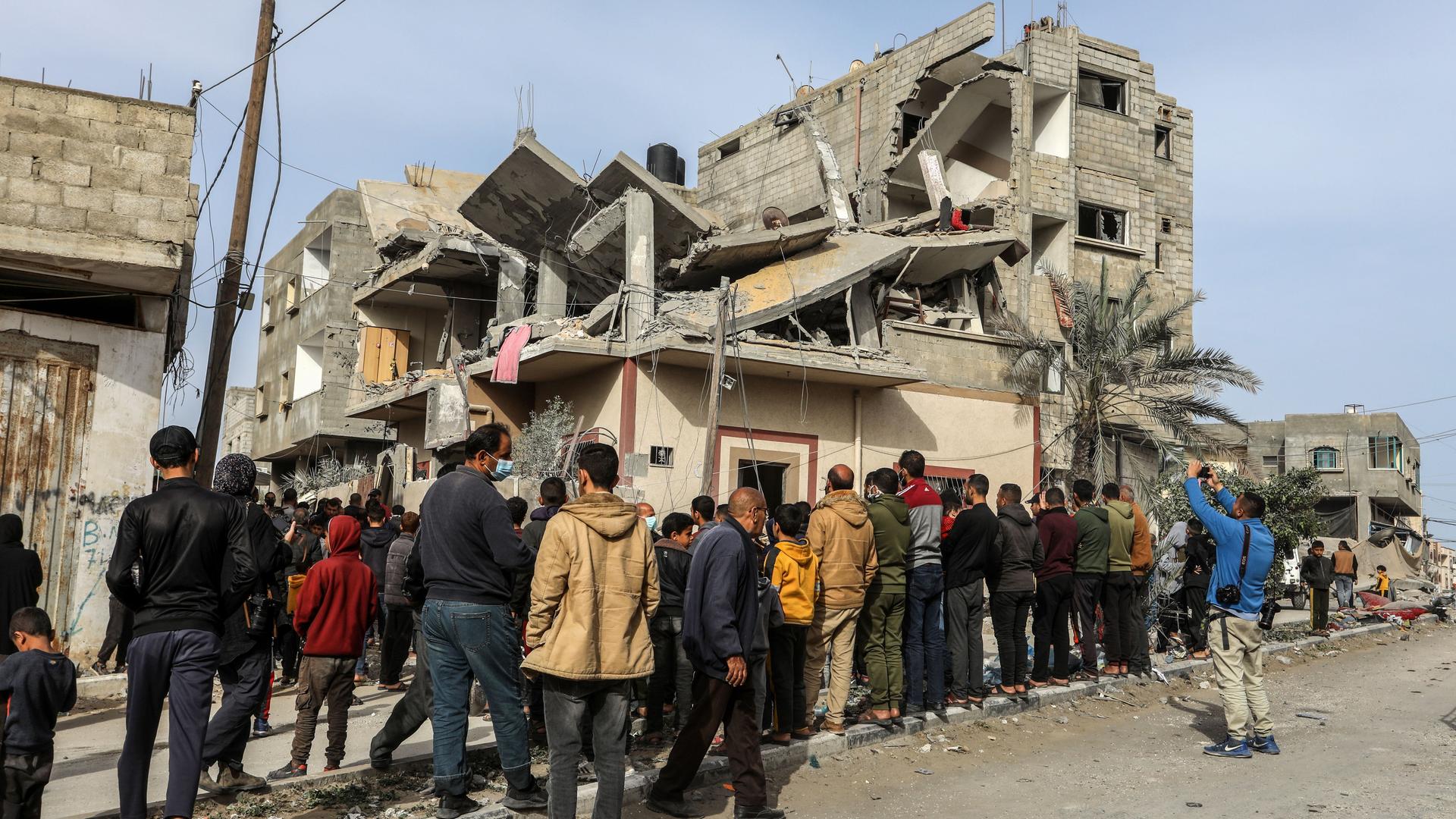 Palästinensische Gebiete, Rafah: Palästinenser versammeln sich nach einem israelischen Luftangriff um ein zerstörtes Haus einer Familie.
