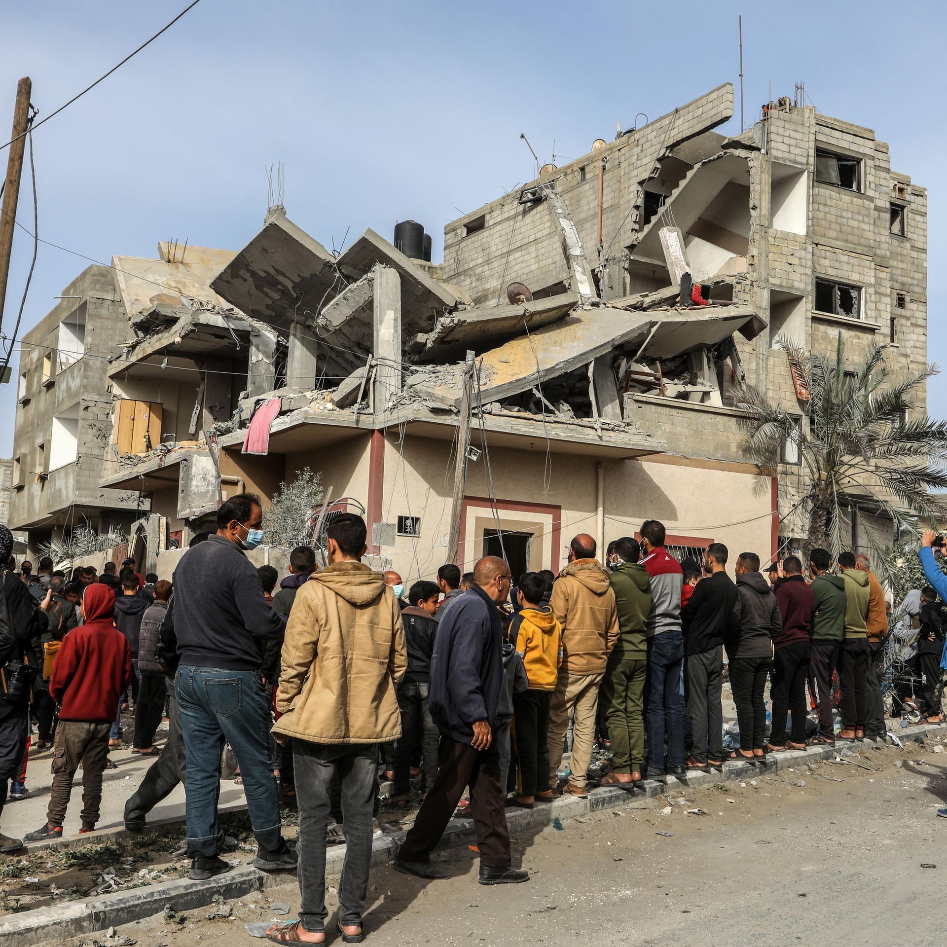 Palästinensische Gebiete, Rafah: Palästinenser versammeln sich nach einem israelischen Luftangriff um ein zerstörtes Haus einer Familie. 