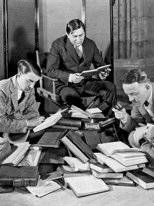 Ernst Lubitsch und zwei andere Männer lesend mit einem Haufen von Büchern Ernst Lubitsch und zwei andere Männer lesend mit einem Haufen von Büchern