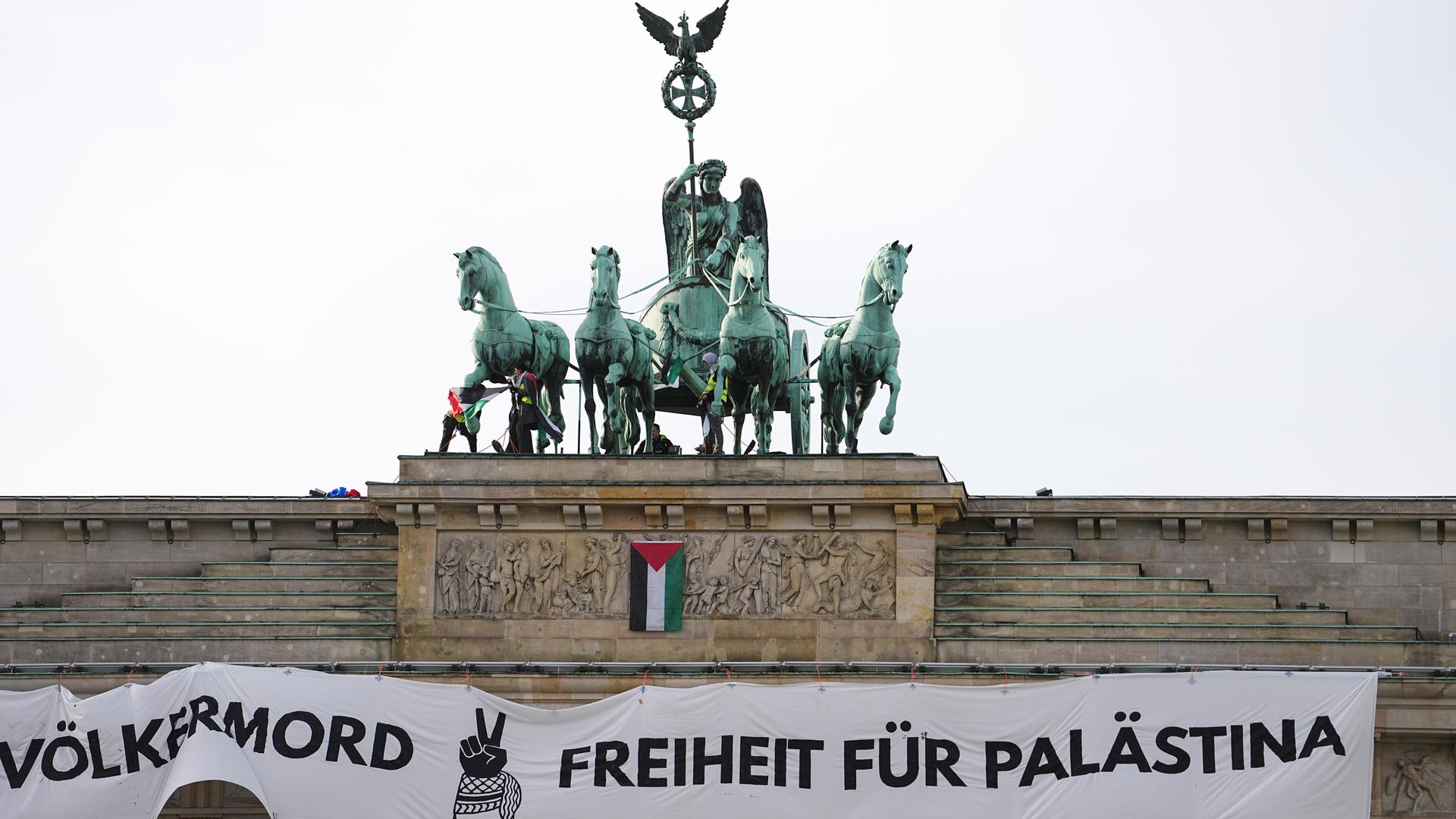 Mehrere Demonstranten sind auf das Brandenburger Tor in Berlin geklettert und haben ein propalästinensisches Transparent aufgehängt. 