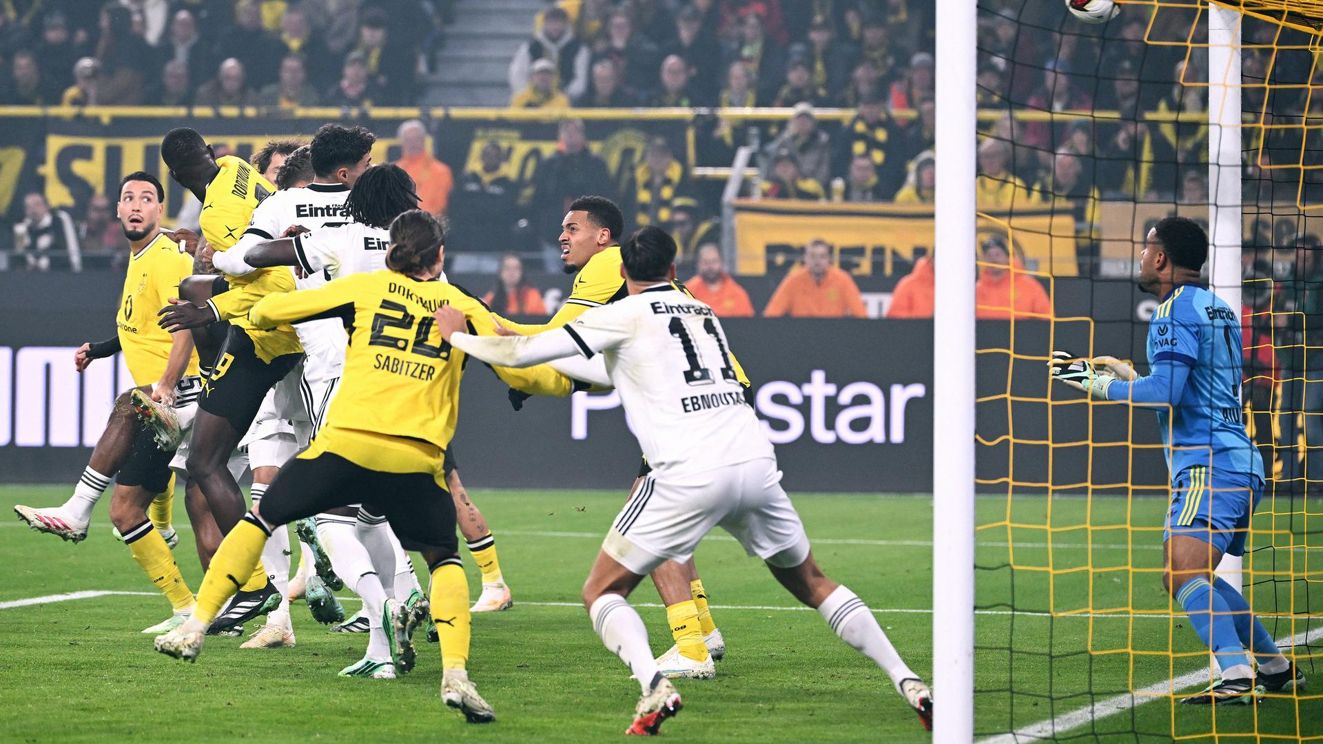 Fußball-Bundesliga: Dortmund spielt gegen Frankfurt; Spieler beider Mannschaften vor dem Tor, in dem der Frankfurter Torwart steht.