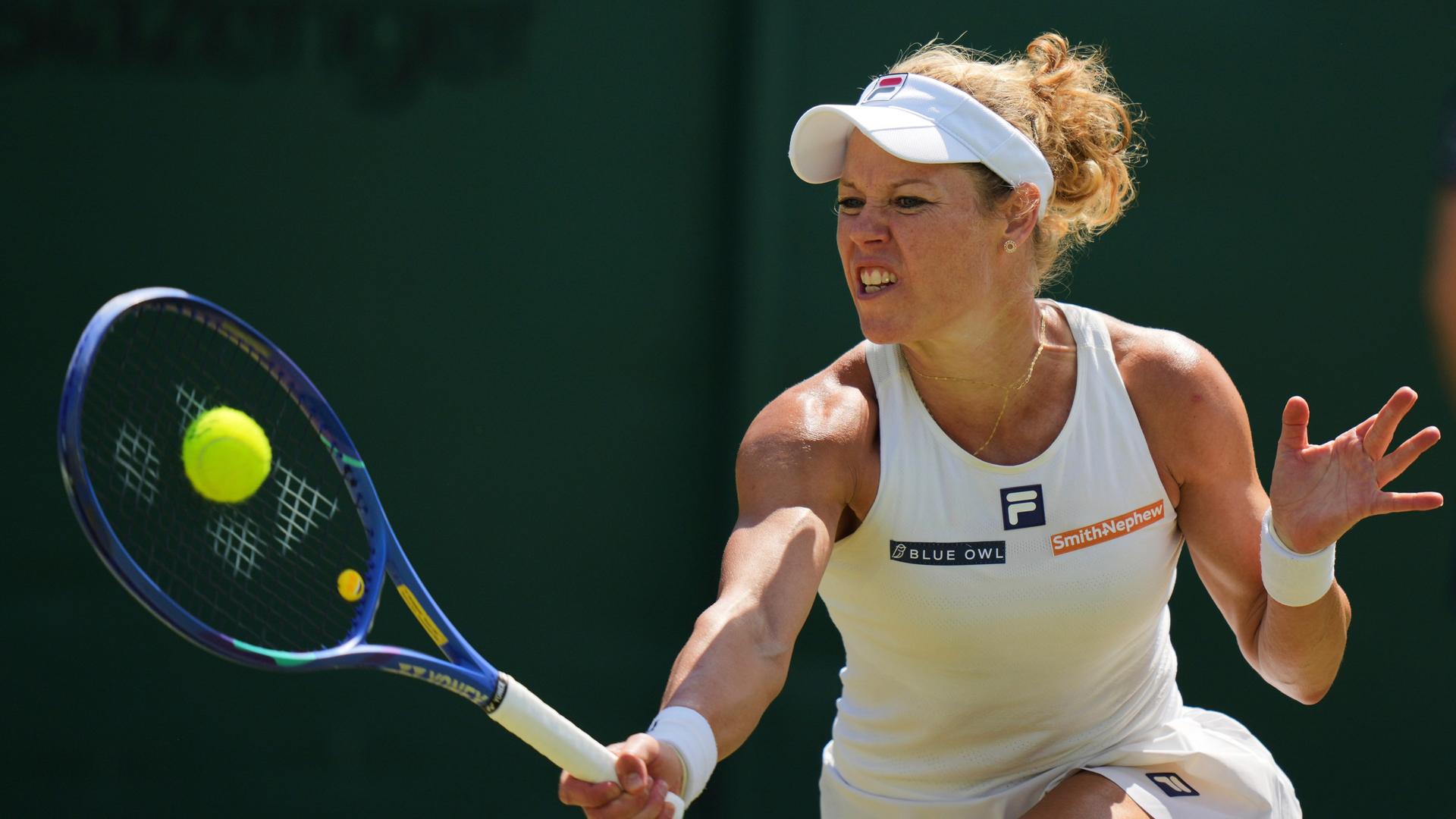 Tennisprofi Laura Siegemund steht in Wimbledon auf dem Platz. Sie spielt eine Vorhand. 