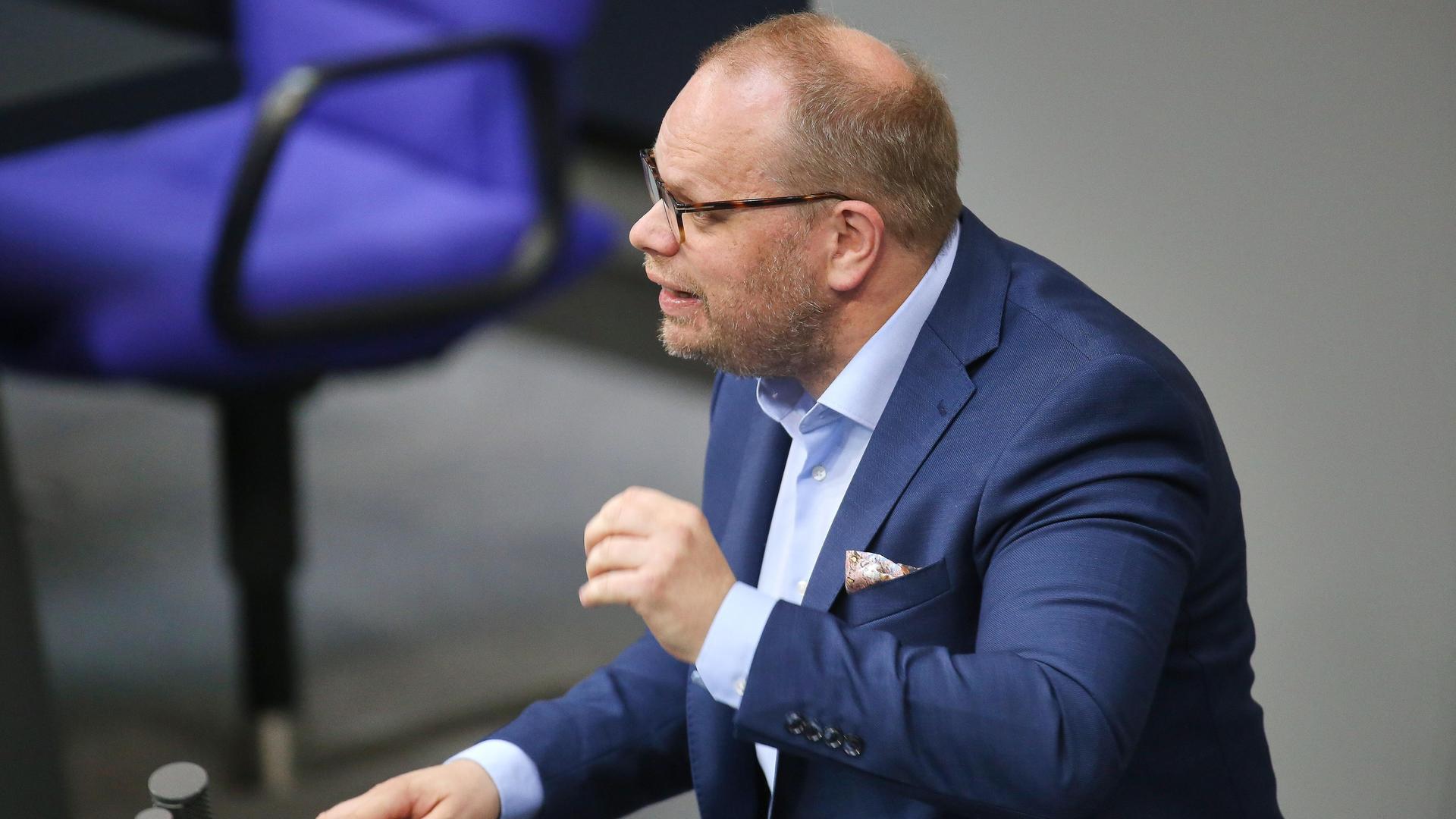 Helge Lindh steht bei einer Rede im Bundestag mit einem blauen Anzug am Rednerpult und gestikuliert.