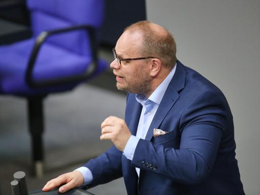 Helge Lindh steht bei einer Rede im Bundestag mit einem blauen Anzug am Rednerpult und gestikuliert. Helge Lindh steht bei einer Rede im Bundestag mit einem blauen Anzug am Rednerpult und gestikuliert.