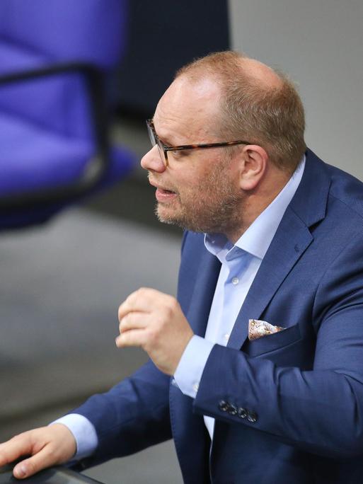 Helge Lindh steht bei einer Rede im Bundestag mit einem blauen Anzug am Rednerpult und gestikuliert. Helge Lindh steht bei einer Rede im Bundestag mit einem blauen Anzug am Rednerpult und gestikuliert.