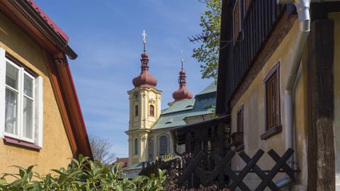 Blick durch Wohnhäuser hindurch auf das Franziskaner-Kloster in Hejnice im Dreiländereck von Tschechien, Polen und Deutschland.