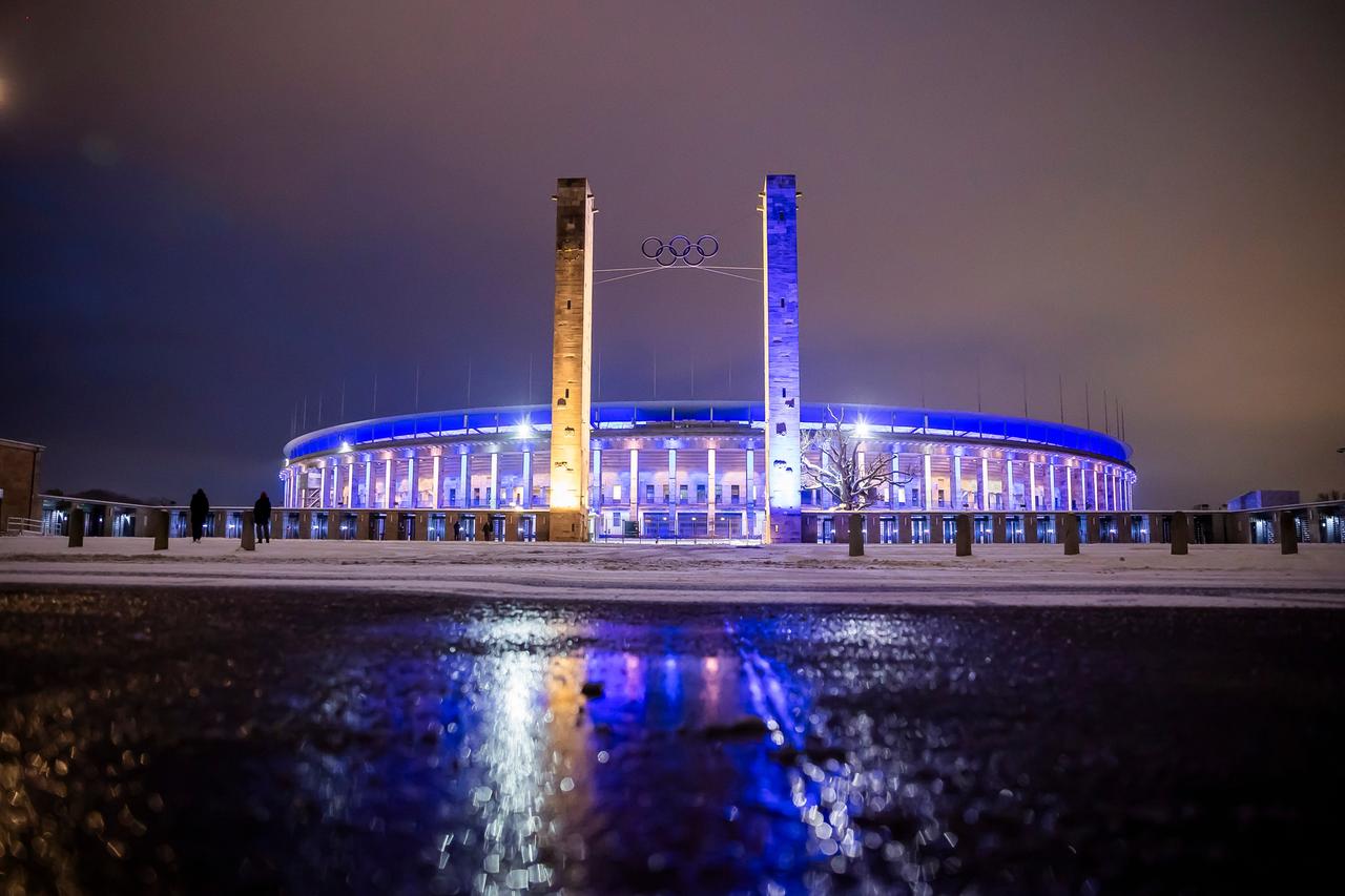 Ein Stadion wird blau und weiß angeleuchtet. 