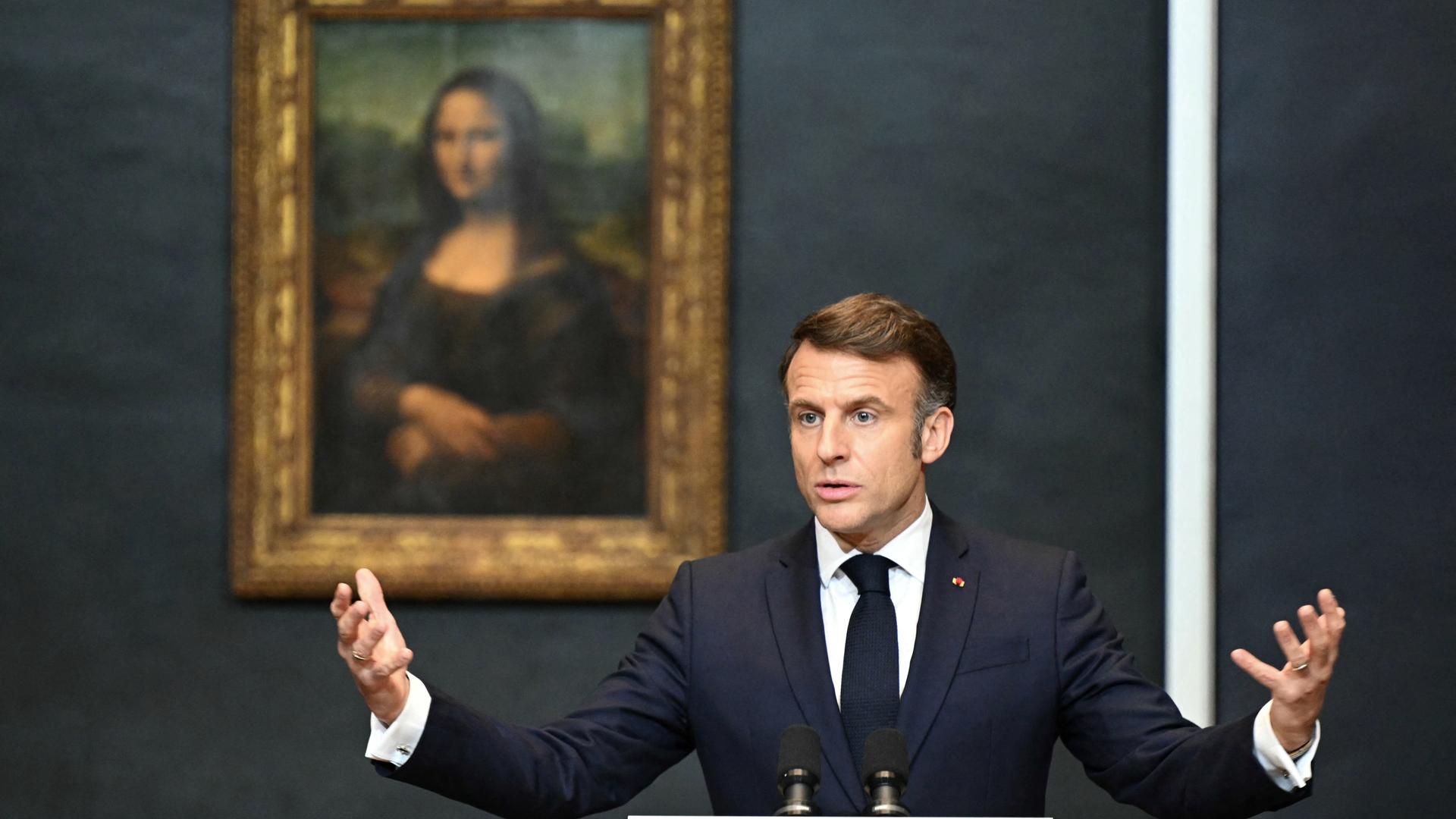 Emmanuel Macron spricht zur Presse und steht dabei vor dem berühmten Gemälde "Mona Lisa"