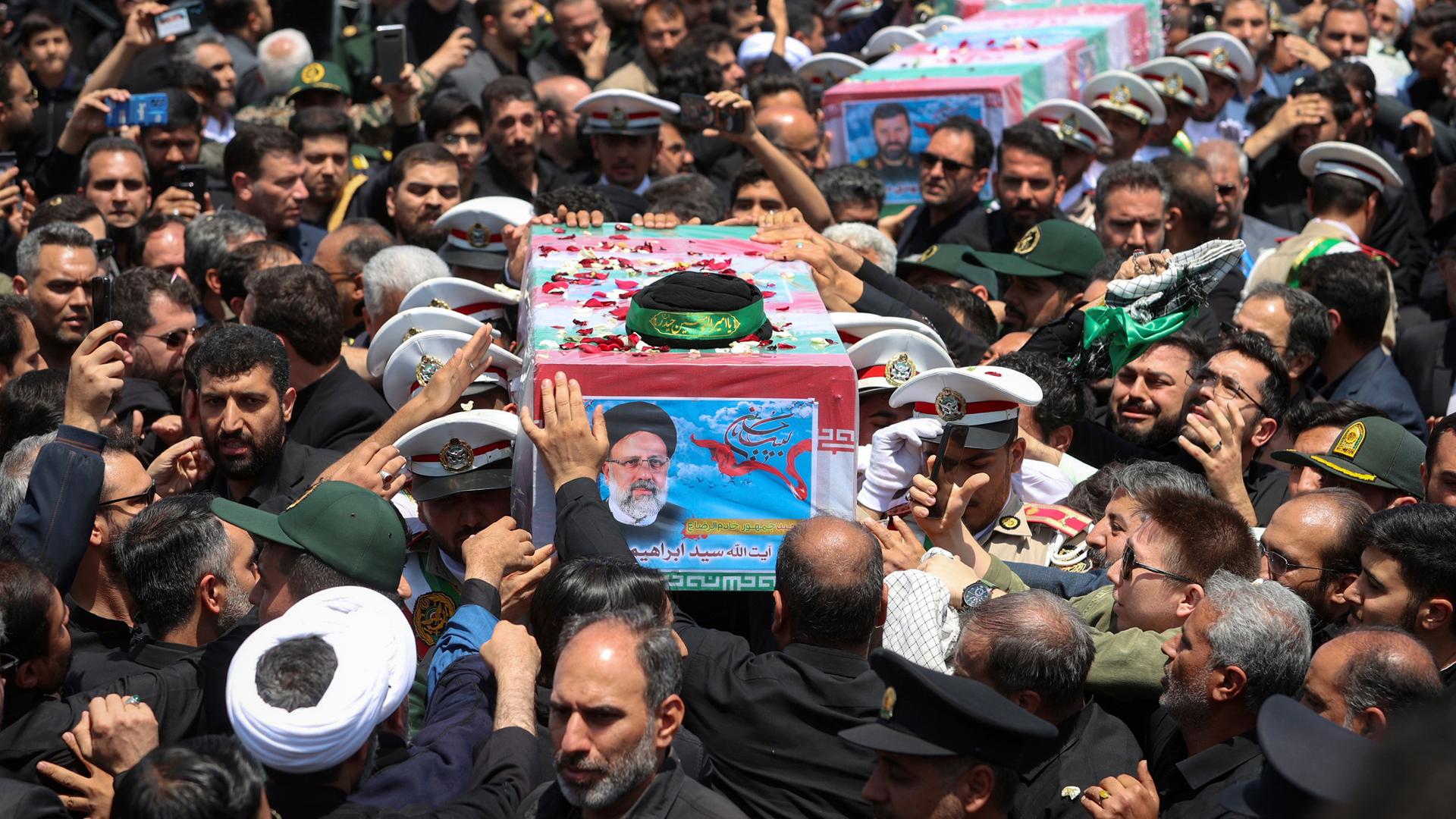 Der in eine Flagge gehüllte Sarg mit den sterblichen Überresten des tödlich verunglückten Präsidenten Ebrahim Raisi wird durch eine Menschenmenge getragen.