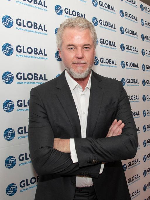 Eric Dane vor einer Wand mit der Aufschrift einer Organisation für Menschen mit Down-Syndrom