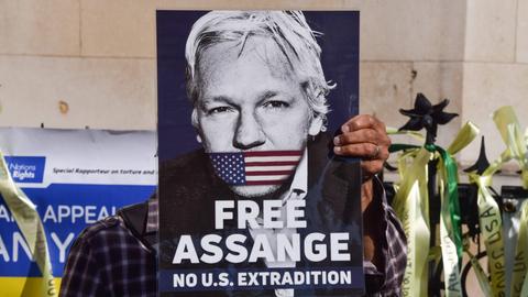 Demonstration für Julian Assange vor dem High Court in London im Mai 2024. Eine Person hält ein Schild mit dem Bild Assanges in die Höhe.