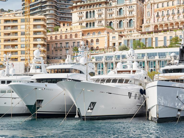 Luxusyachten liegen nebeneinander im Hafen von Monte Carlo.