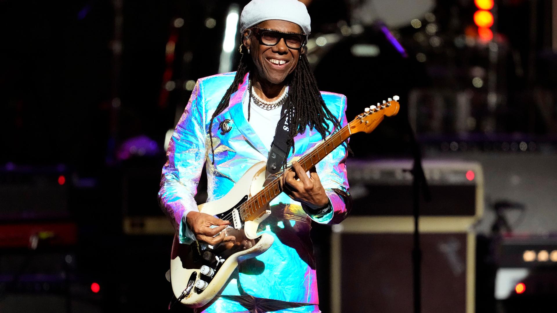 Nile Rodgers spielt auf einer Bühne Gitarre. Nile Rodgers spielt auf einer Bühne Gitarre.