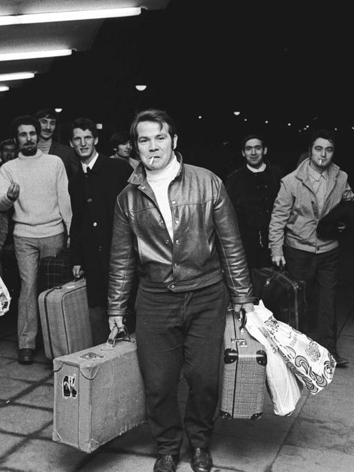 Fotografie aus dem Jahr 1970: Am Bahnhof in Wolfsburg laufen italienische VW-Gastarbeiter aus Italien mit Koffern und Taschen auf dem Bahnsteig entlang.