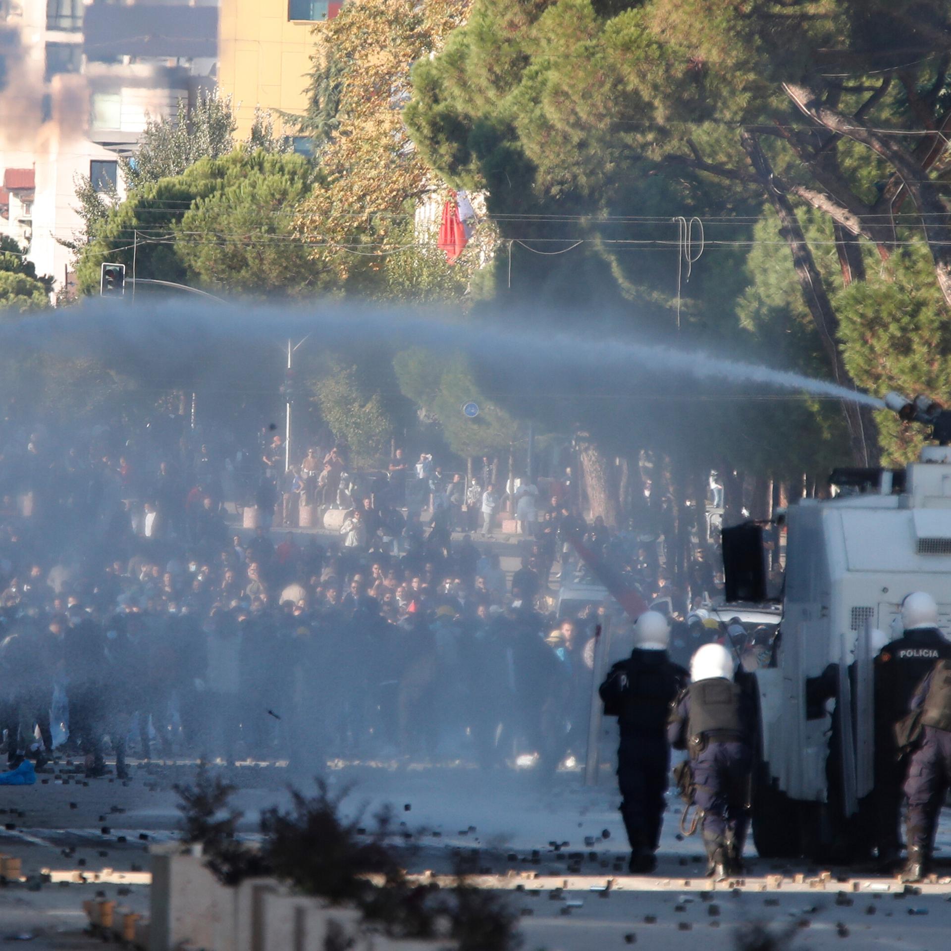 Die Polizei steht einer Menge Demonstranten gegenüber. Ein Wasserwerfer ist im Einsatz.