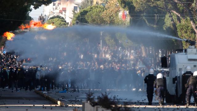 Die Polizei steht einer Menge Demonstranten gegenüber. Ein Wasserwerfer ist im Einsatz.