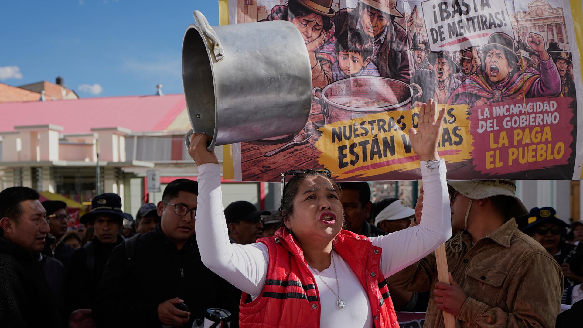 Eine Lehrerin hält während einer regierungskritischen Demonstration in La Paz, Bolivien, einen leeren Topf in der Hand.