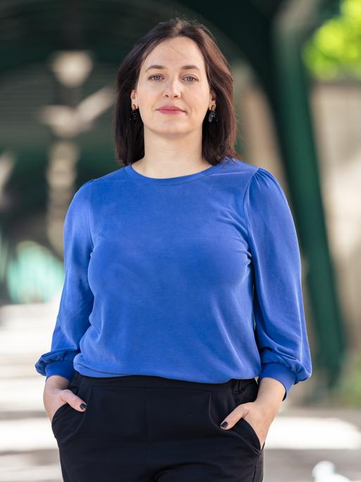 Porträt von Ina Lucas in einem blauen Oberteil und schwarzer Hose