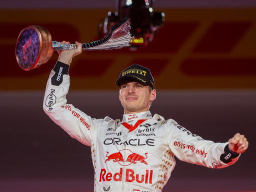 Formel-1-Fahrer Max Verstappen hält die Trophäe für seinen Sieg beim Grand Prix in Las Vegas triumphierend in die Luft.